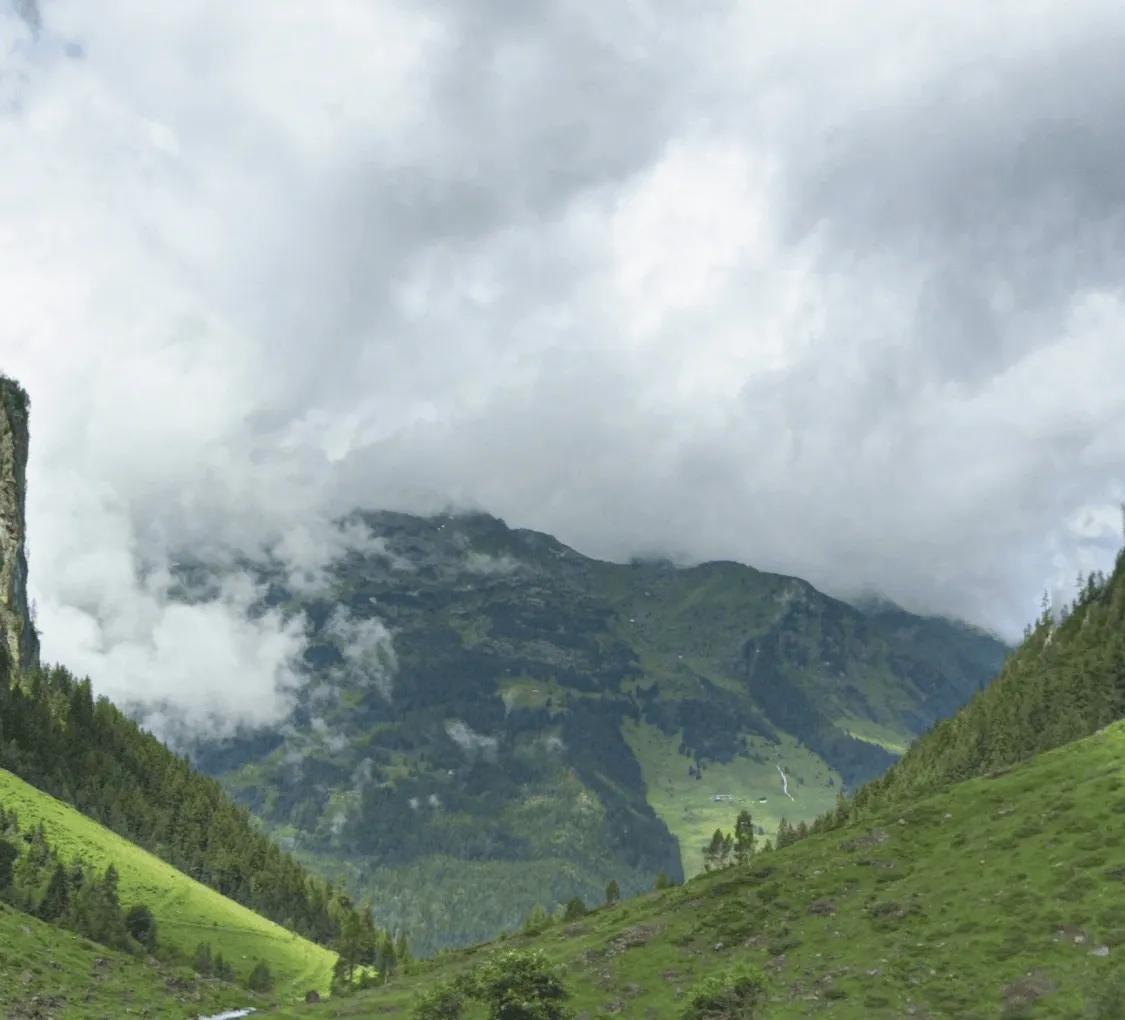 Berglandschaft mit Wolken über einem grünen Tal