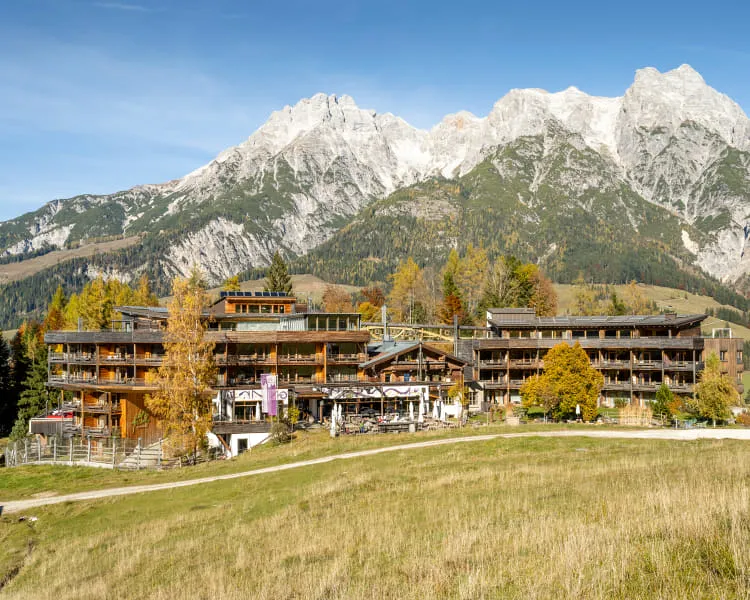 Berglandschaft mit mehreren Holzhäusern und Bergen im Hintergrund